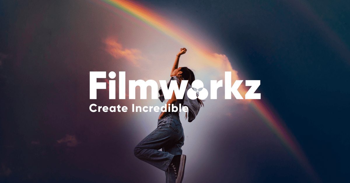 A Person Stands And Raises One Arm Against The Backdrop Of A Blue Sky With A Double Rainbow. The Text In Bold White Letters Reads &Quot;Filmworkz Phoenix,&Quot; With The Subtitle &Quot;Create Incredible&Quot; Below It.